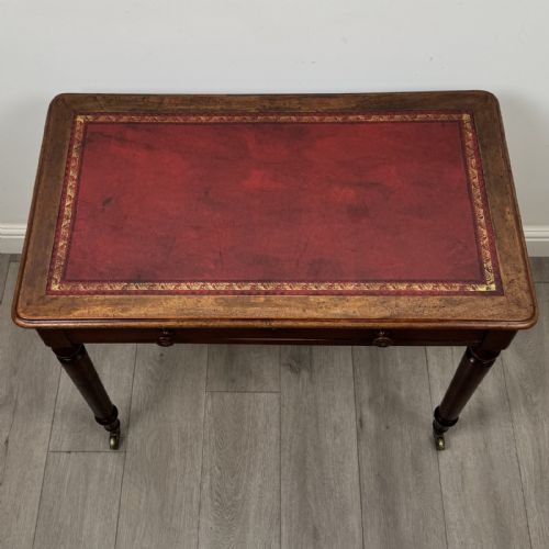 fig 8. Victorian mahogany writing table featuring a single frieze drawer with turned wooden knobs and four turned legs on brass castors.