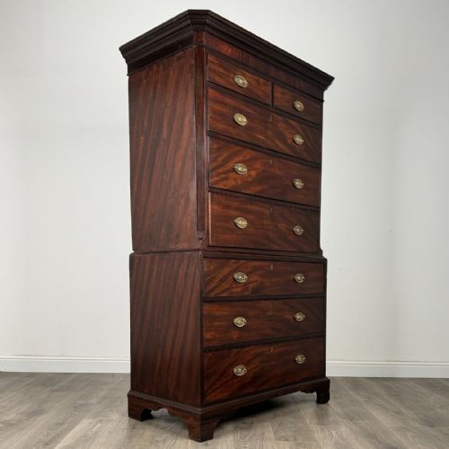 fig 5. An 18th-century Georgian mahogany chest on chest featuring two short over six long drawers with oval brass handles and bracket feet.