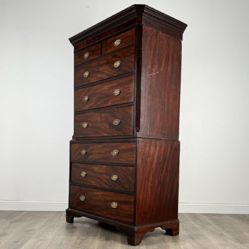 fig 6. An 18th-century Georgian mahogany chest on chest featuring two short over six long drawers with oval brass handles and bracket feet.