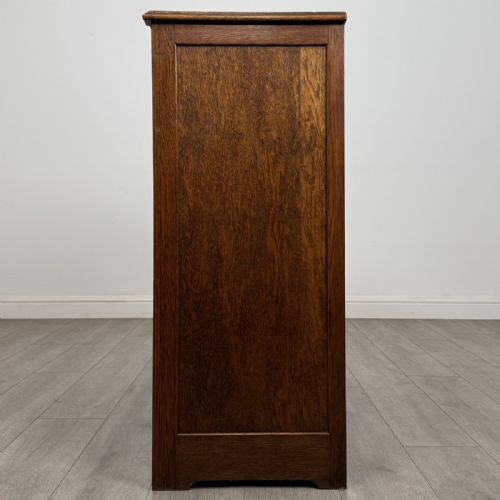 fig 3. An antique dark oak fitted cupboard featuring a smooth top section above two panelled lower cupboard doors.