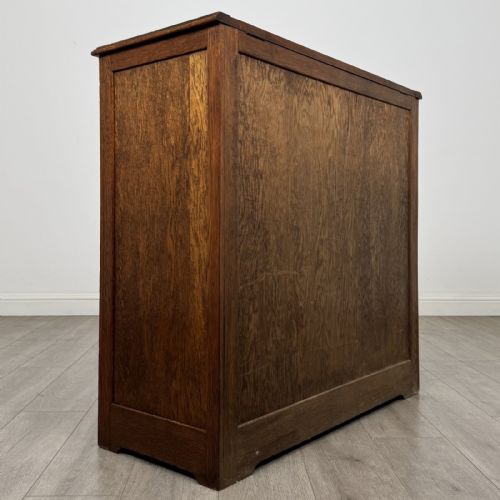 fig 4. An antique dark oak fitted cupboard featuring a smooth top section above two panelled lower cupboard doors.