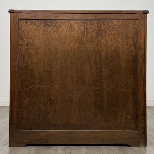 fig 5. An antique dark oak fitted cupboard featuring a smooth top section above two panelled lower cupboard doors.
