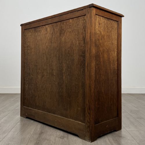 fig 6. An antique dark oak fitted cupboard featuring a smooth top section above two panelled lower cupboard doors.