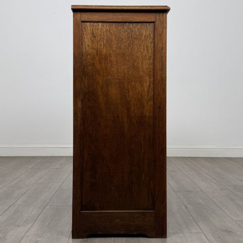 fig 7. An antique dark oak fitted cupboard featuring a smooth top section above two panelled lower cupboard doors.