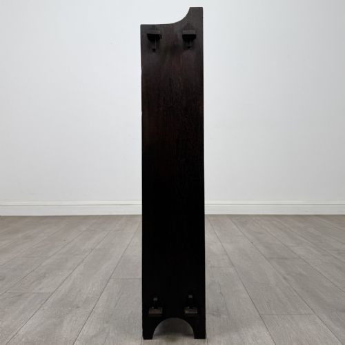 fig 3. A compact dark oak open bookcase featuring four tiered shelves, side uprights with exposed tenon projections, and a low top gallery rail.