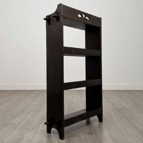 fig 4. A compact dark oak open bookcase featuring four tiered shelves, side uprights with exposed tenon projections, and a low top gallery rail.