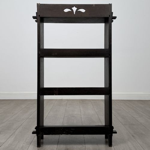 fig 5. A compact dark oak open bookcase featuring four tiered shelves, side uprights with exposed tenon projections, and a low top gallery rail.