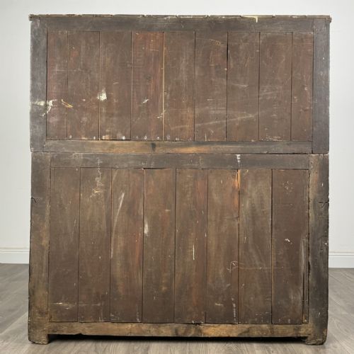 fig 5. An 18th-century Georgian dark oak Welsh deuddarn cupboard featuring carved upper panels dated 1743, turned drop pendants, and panelled cupboard doors.