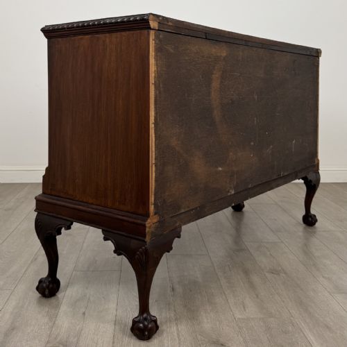 fig 4. An Edwardian mahogany sideboard with three central drawers flanked by cupboard doors featuring oval mahogany veneers and carved cabriole legs terminating in ball-and-claw feet.
