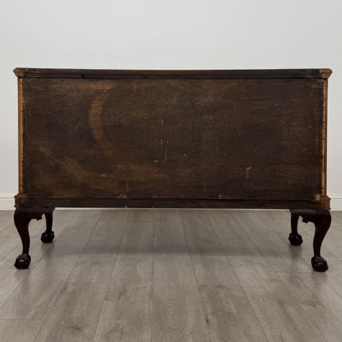 fig 5. An Edwardian mahogany sideboard with three central drawers flanked by cupboard doors featuring oval mahogany veneers and carved cabriole legs terminating in ball-and-claw feet.