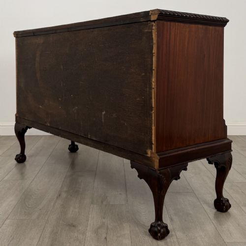 fig 6. An Edwardian mahogany sideboard with three central drawers flanked by cupboard doors featuring oval mahogany veneers and carved cabriole legs terminating in ball-and-claw feet.