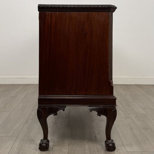 fig 7. An Edwardian mahogany sideboard with three central drawers flanked by cupboard doors featuring oval mahogany veneers and carved cabriole legs terminating in ball-and-claw feet.