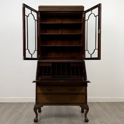fig 1. An Edwardian walnut bureau bookcase with a glazed upper cabinet, slant-front writing desk, three drawers, and cabriole legs on claw and ball feet.