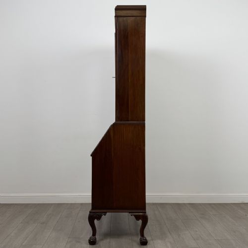 fig 3. An Edwardian walnut bureau bookcase with a glazed upper cabinet, slant-front writing desk, three drawers, and cabriole legs on claw and ball feet.