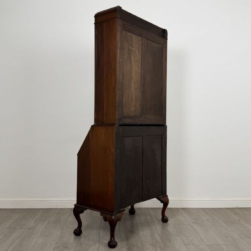 fig 4. An Edwardian walnut bureau bookcase with a glazed upper cabinet, slant-front writing desk, three drawers, and cabriole legs on claw and ball feet.