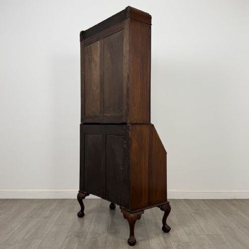 fig 6. An Edwardian walnut bureau bookcase with a glazed upper cabinet, slant-front writing desk, three drawers, and cabriole legs on claw and ball feet.