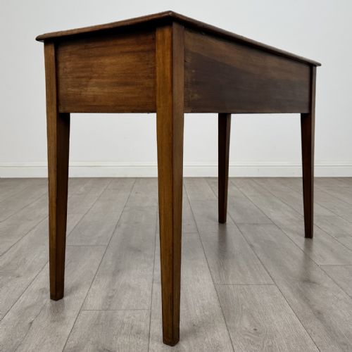 fig 3. An antique Georgian style mahogany side table featuring two front drawers with oval brass handles and four tapered square legs.