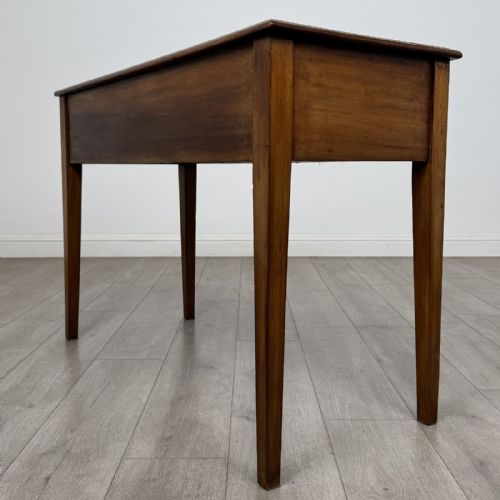 fig 5. An antique Georgian style mahogany side table featuring two front drawers with oval brass handles and four tapered square legs.