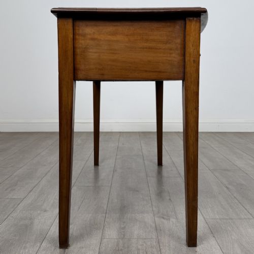 fig 6. An antique Georgian style mahogany side table featuring two front drawers with oval brass handles and four tapered square legs.