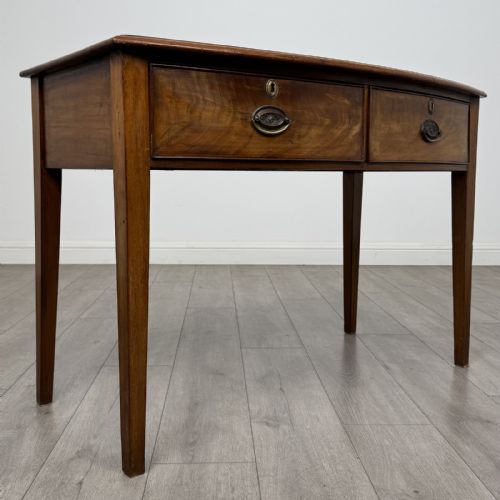 fig 7. An antique Georgian style mahogany side table featuring two front drawers with oval brass handles and four tapered square legs.