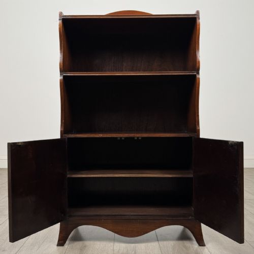 fig 2. An antique mahogany open bookcase featuring a shaped raised gallery top, two upper shelf spaces, and a lower two-door cabinet with flame mahogany veneered panels.