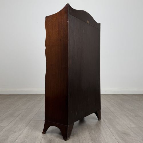 fig 5. An antique mahogany open bookcase featuring a shaped raised gallery top, two upper shelf spaces, and a lower two-door cabinet with flame mahogany veneered panels.