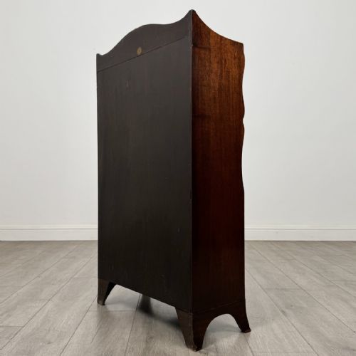 fig 7. An antique mahogany open bookcase featuring a shaped raised gallery top, two upper shelf spaces, and a lower two-door cabinet with flame mahogany veneered panels.