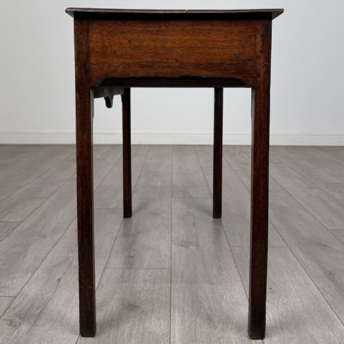 fig 2. An 18th-century Georgian dark oak side table featuring a single drawer with pierced brass handles and straight square legs.