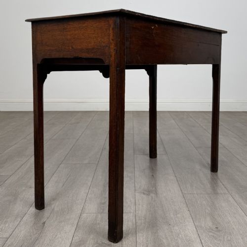 fig 3. An 18th-century Georgian dark oak side table featuring a single drawer with pierced brass handles and straight square legs.
