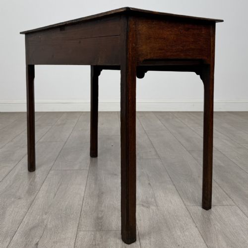fig 5. An 18th-century Georgian dark oak side table featuring a single drawer with pierced brass handles and straight square legs.