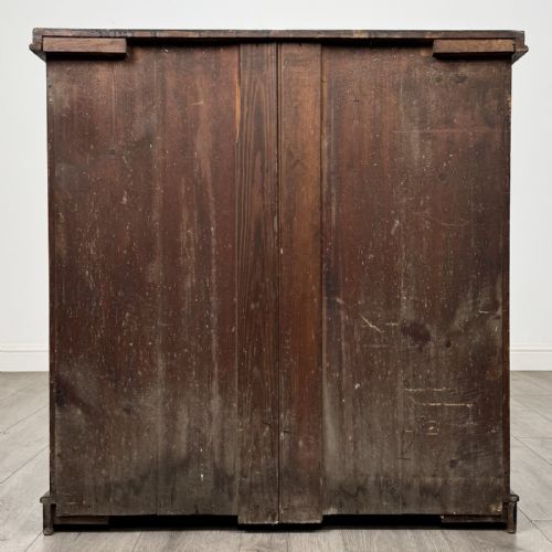 fig 4. A Victorian mahogany chest of drawers featuring a two-over-three drawer configuration, brass cup handles, and a plinth base.