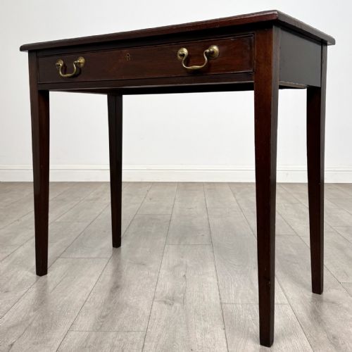 fig 1. An 18th-century Georgian mahogany writing table featuring a single long drawer with two brass swan-neck handles and four square tapered legs.