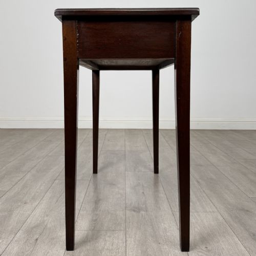 fig 2. An 18th-century Georgian mahogany writing table featuring a single long drawer with two brass swan-neck handles and four square tapered legs.