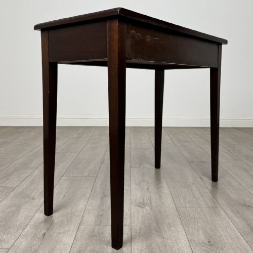 fig 3. An 18th-century Georgian mahogany writing table featuring a single long drawer with two brass swan-neck handles and four square tapered legs.
