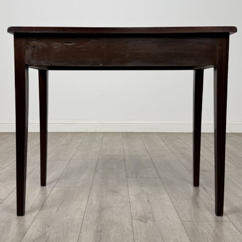 fig 4. An 18th-century Georgian mahogany writing table featuring a single long drawer with two brass swan-neck handles and four square tapered legs.
