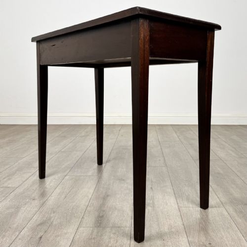 fig 5. An 18th-century Georgian mahogany writing table featuring a single long drawer with two brass swan-neck handles and four square tapered legs.