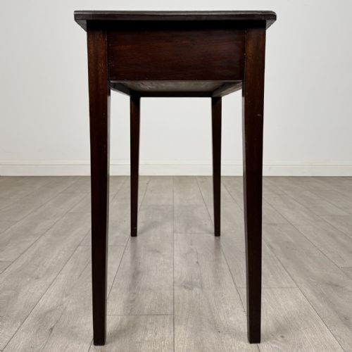 fig 6. An 18th-century Georgian mahogany writing table featuring a single long drawer with two brass swan-neck handles and four square tapered legs.