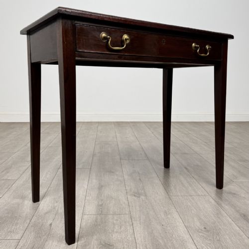 fig 7. An 18th-century Georgian mahogany writing table featuring a single long drawer with two brass swan-neck handles and four square tapered legs.