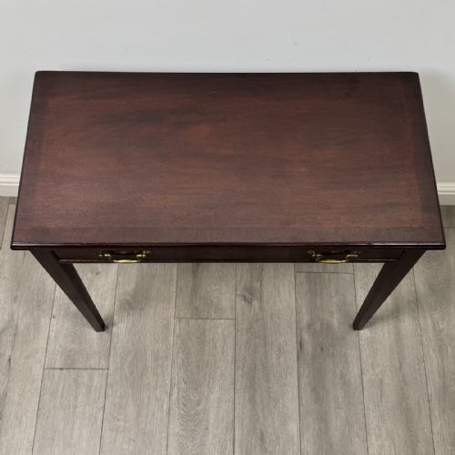 fig 8. An 18th-century Georgian mahogany writing table featuring a single long drawer with two brass swan-neck handles and four square tapered legs.