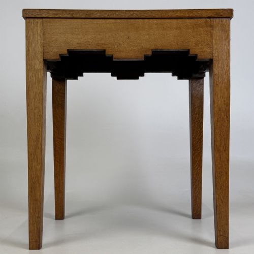 fig 2. A tall, slender Arts and Crafts golden oak side table featuring tapered square legs and a notched, stepped apron.