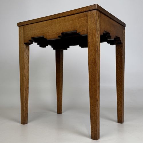 fig 3. A tall, slender Arts and Crafts golden oak side table featuring tapered square legs and a notched, stepped apron.
