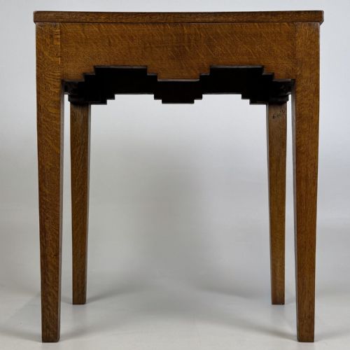 fig 6. A tall, slender Arts and Crafts golden oak side table featuring tapered square legs and a notched, stepped apron.