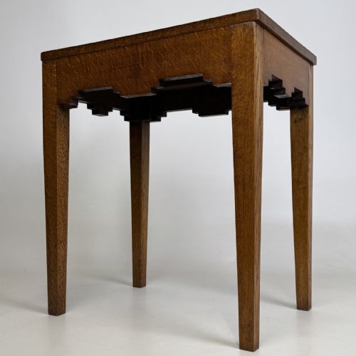 fig 7. A tall, slender Arts and Crafts golden oak side table featuring tapered square legs and a notched, stepped apron.