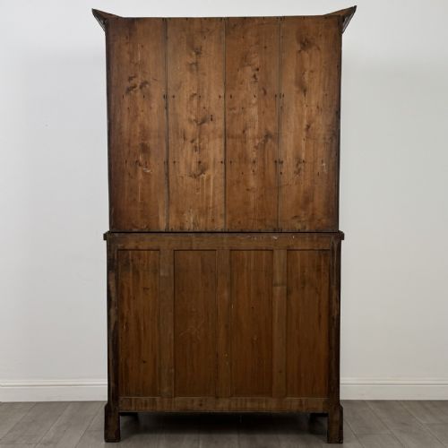fig 6. An 18th-century Georgian golden oak glazed bookcase resting upon a chest of three long drawers with turned wooden handles and shaped bracket feet.