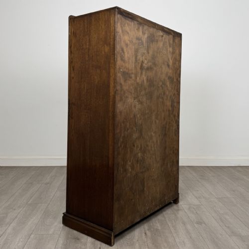 fig 4. A tall dark brown oak double wardrobe featuring hand-carved Gothic tracery panels on top and vertical panel detail below.