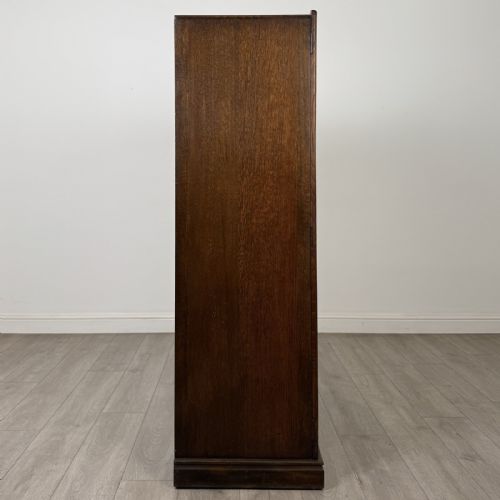 fig 7. A tall dark brown oak double wardrobe featuring hand-carved Gothic tracery panels on top and vertical panel detail below.