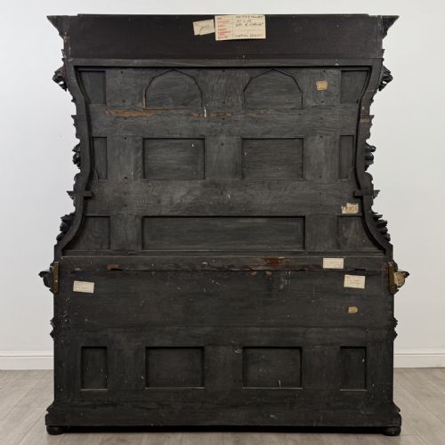 fig 4. An ornate ebonised dark wood Victorian sideboard featuring upper tier shelves with carved arches, lion masks, and lower drawers with brass drop handles.