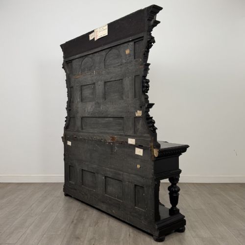 fig 5. An ornate ebonised dark wood Victorian sideboard featuring upper tier shelves with carved arches, lion masks, and lower drawers with brass drop handles.