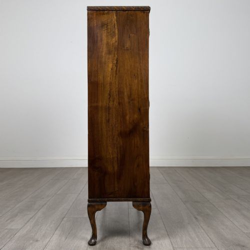 fig 7. An antique Edwardian mahogany display cabinet featuring twin glazed doors, glass interior shelving, and cabriole legs.
