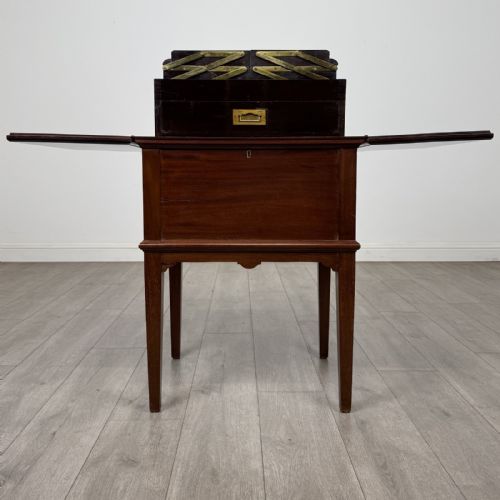 fig 1. A 19th-century mahogany fold-out cabinet standing on four square tapered legs with a brass keyhole escutcheon on the front casing.